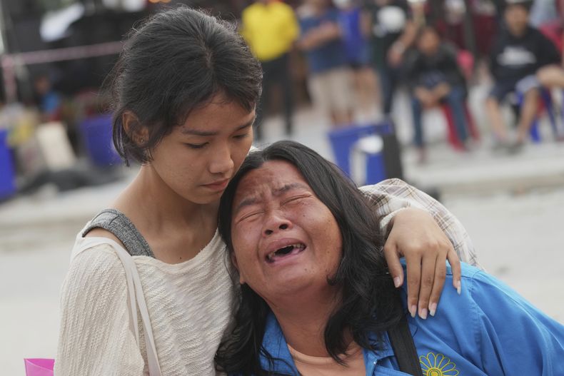 Una mujer reacciona tras ser informada que su esposo ha muerto en un rascacielos en construcción en Bangkok, Tailandia, el domingo 30 de marzo de 2025. (AP Foto/Sakchai Lalit)