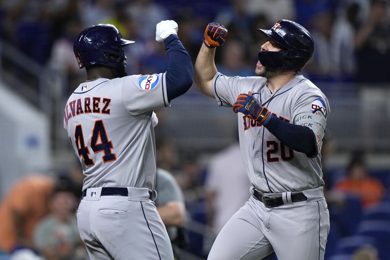 Chas McCormick (derecha), de los Astros de Houston, festeja con el cubano Yordan Álvarez, luego de empujarlo con un jonrón en el duelo del miércoles 16 de agosto de 2023, ante los Marlins de Miami (AP Foto/Wilfredo Lee)