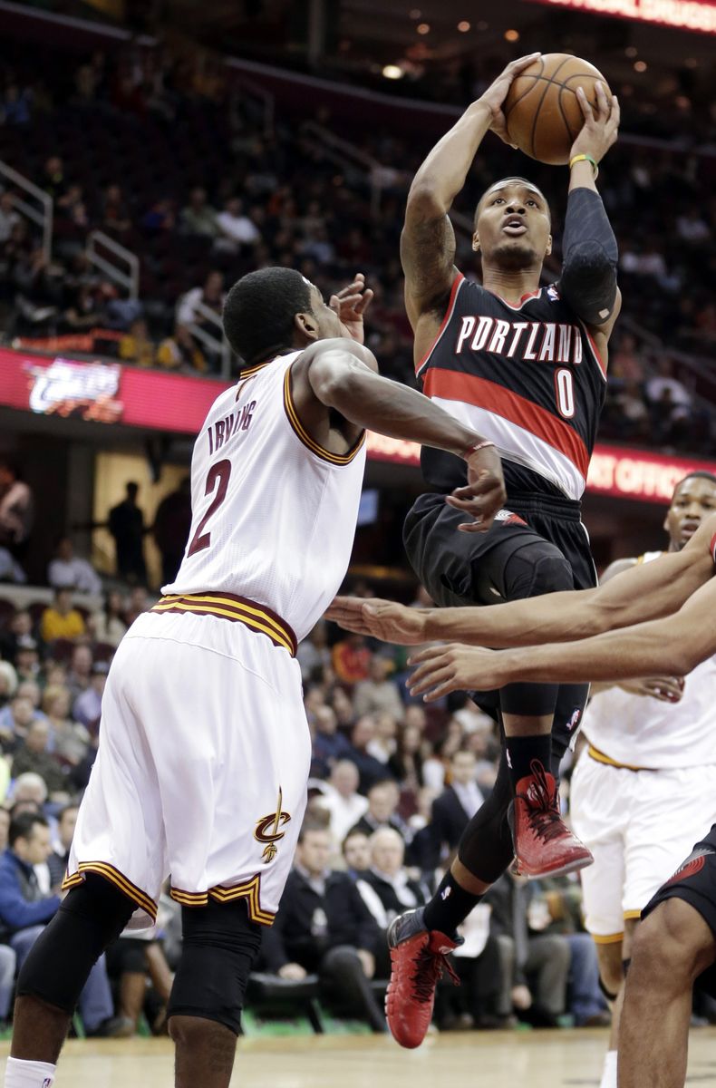 Damian Lillard, de los Trail Blazers de Portland, salta para disparar frente a Kyrie Irving, de los Cavaliers de Cleveland, el martes 17 de diciembre de 2013 (AP Foto/Tony Dejak)