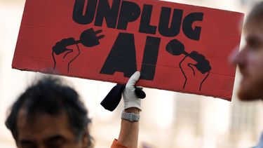 ARCHIVO - Un pequeño grupo de personas a favor de implementar restricciones a la inteligencia artificial sostiene pancartas frente al ayuntamiento de Nueva York el 5 de octubre de 2026, antes de una audiencia del Concejo Municipal sobre la seguridad de la IA en la ciudad. (AP Foto/Seth Wenig, archivo)