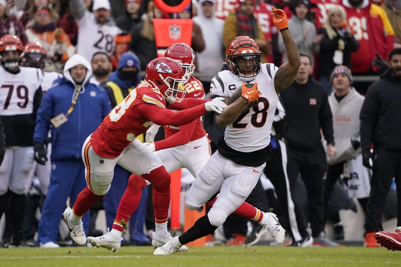 Joe Mixon (28), running back de los Bengals de Cincinnati, corre con el balón mientras el cornerback LJarius Sneed, izquierda, de los Chiefs de Kansas City, busca detenerlo en la primera mitad del juego de la NFL, el domingo 31 de diciembre de 2023, en Kansas City, Missouri. (AP Foto/Ed Zurga)
