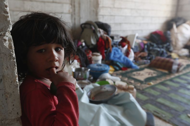 Una niña beduina desplazada se ve dentro de un refugio después de que su familia abandonara su casa debido a enfrentamientos entre clanes beduinos y milicias drusas, en el poblado de Busra al-Harir, en el sur de Siria, el domingo 20 de julio de 2025. (AP Foto/Omar Sanadiki)