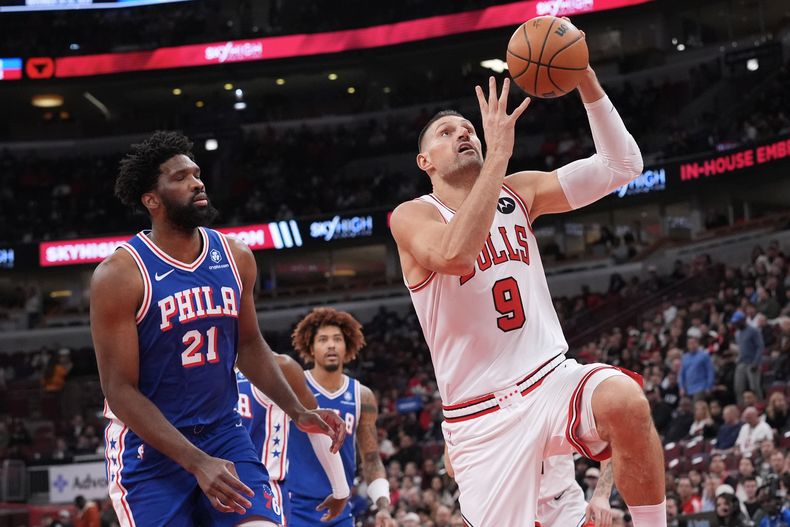 El pívot de los Bulls de Chicago Nikola Vučević avanza con el balón hacia la canasta frente a Joel Embiid de los 76ers de Filadelfia el martes 4 de noviembre del 2025. (AP Foto/Nam Y. Huh)