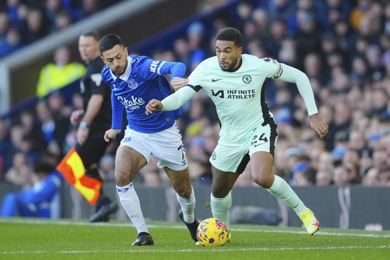 Reece James, del Chelsea, se lleva un balón junto a Dwight McNeil (izquierda), del Everton, en el duelo del domingo 10 de diciembre de 2023 (AP Foto/Jon Super)