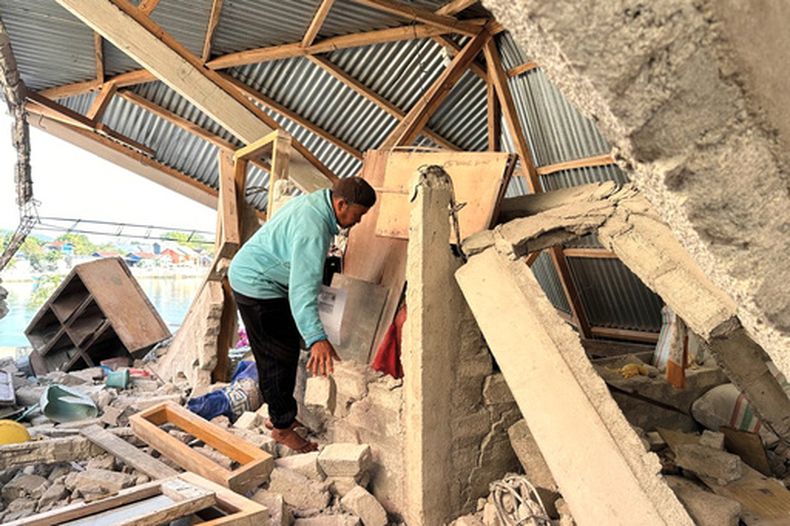 Arshad Hamid, sobreviviente del sismo, busca objetos de su casa dañada en North Lamba Leda, en la provincia de Nusa Tenggara Oriental, Indonesia, el 19 de agosto de 2026. (AP Foto/Firdia Lisnawati)