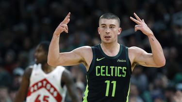 Payton Pritchard (11), de los Celtics de Boston, celebra su triple frente a Davion Mitchell (45), de los Raptors de Toronto, durante la primera mitad de un partido de baloncesto de la NBA, el martes 31 de diciembre de 2024, en Boston. (AP Foto/Michael Dwyer)