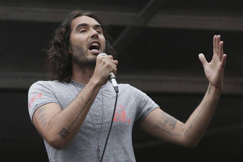 ARCHIVO - El comediante Russell Brand habla en Parliament Square durante una protesta contra el Gobierno conservador y sus políticas de austeridad en Londres, el sábado 20 de junio de 2015. (Foto AP/Tim Ireland, archivo)