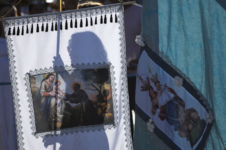Una mujer sostiene el estandarte de Nuestra Señora del Rosario durante el Festival Cavalhadas, el lunes 9 de junio de 2025, en Pirenópolis, estado Goiás, Brasil. (AP Foto/Eraldo Peres)