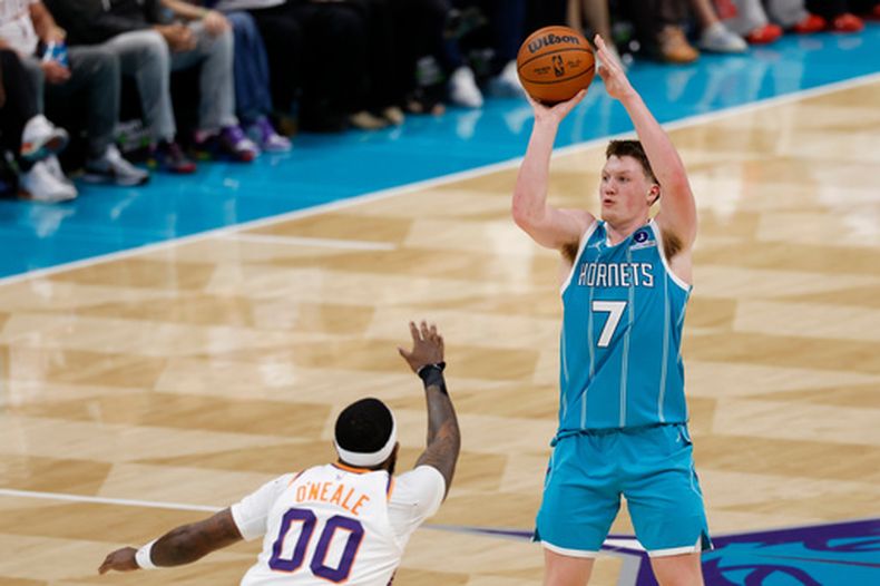 Kon Knueppel, de los Hornets de Charlotte, dispara frente a Royce ONeale, de los Suns de Phoenix, en el partido del jueves 2 de abril de 2026 (AP Foto/Nell Redmond)