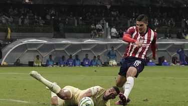 Ronaldo Cisneros, del Guadalajara, anota el primer gol de su equipo al dejar atrás a Sebastián Cáceres, del América, en el partido de vuelta de las semifinales del torneo mexicano, el domingo 21 de mayo de 2023, en la Ciudad de México. (AP Foto/Eduardo Verdugo)
