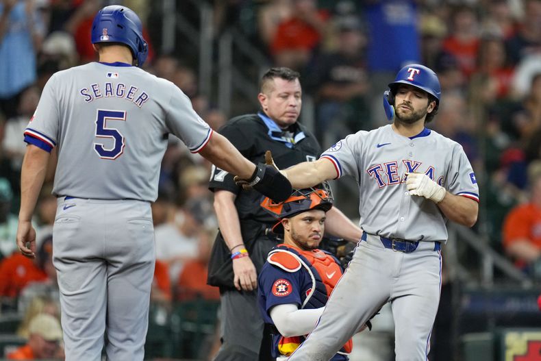 Josh Smith de los Rangers de Texas celebra con Corey Seager tras batear un jonrón de dos carreras en la octava entrada ante los Astros de Houston el domingo 14 de julio del 2024. (AP Foto/Eric Christian Smith)