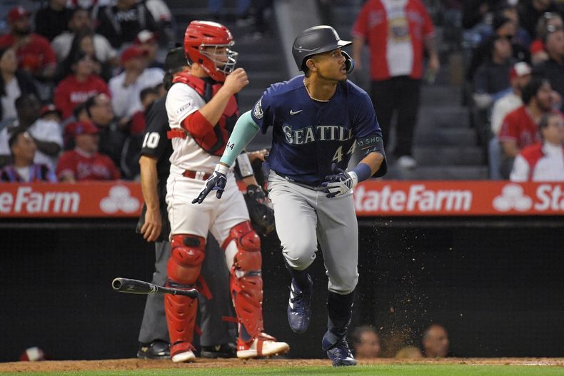 Julio Rodríguez, derecha, de los Marineros de Seattle, se enfila a primera base después de batear un cuadrangular mientras el receptor de los Angelinos de Los Ángeles, Matt Thaiss, observa durante la tercera entrada el juego de béisbol, el sábado 10 de junio de 2023, en Anaheim, California. Rodríguez participará en el Derby de Cuadrangulares en el Juego de Estrellas. (AP Foto/Mark J. Terrill)