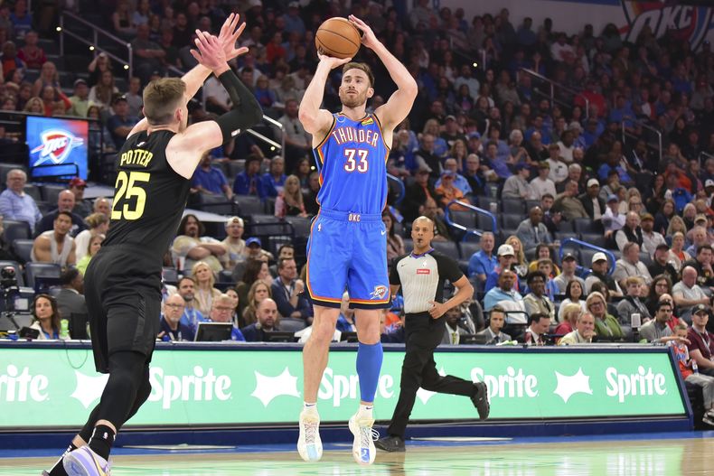 El alero del Thunder de Oklahoma City Gordon Hayward lanza el balón sobre el pívot del Jazz de Utah Micah Porter en el encuentro de la NBA del miércoles 20 de marzo del 2024. (AP Foto/Kyle Phillips)