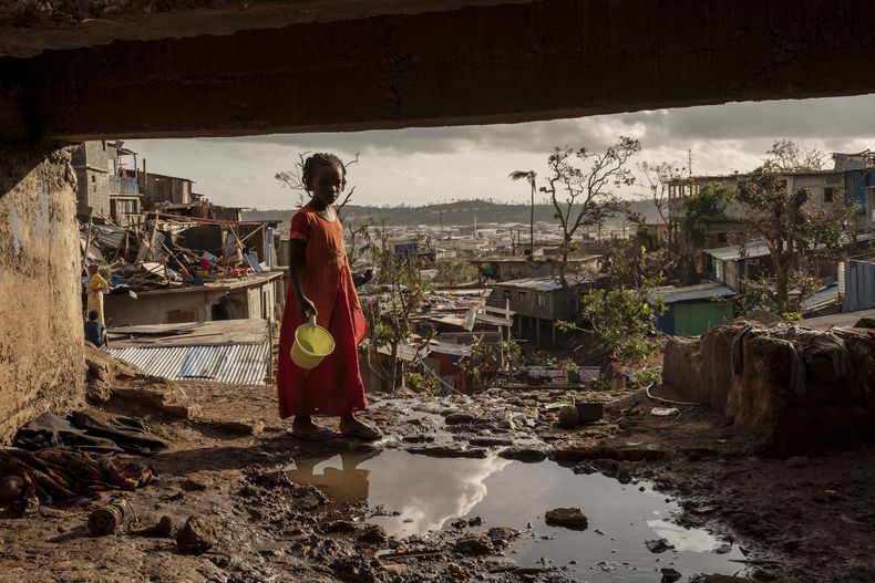 Una niña camina por la barriada de Kaweni, a las afueras de Mamoudzou, en la isla francesa de Mayotte, en el océano Índico, el 19 de diciembre de 2024, tras el paso del ciclón Chido. (AP Foto/Adrienne Surprenant)