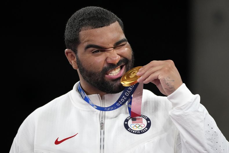 ARCHIVO - Gable Dan Steveson, de Estados Unidos, posa con su medalla de oro durante la ceremonia de premiación en la categoría de 125 kg de lucha libre en los Juegos Olímpicos de 2020, en Chiba, Japón, el 6 de agosto de 2021. Stevenson deja la colchoneta por el campo de juego al firmar contrato como agente libre no reclutado con los Bills de Buffalo el viernes 31 de mayo de 2024. (AP Foto/Aaron Favila, Archivo)