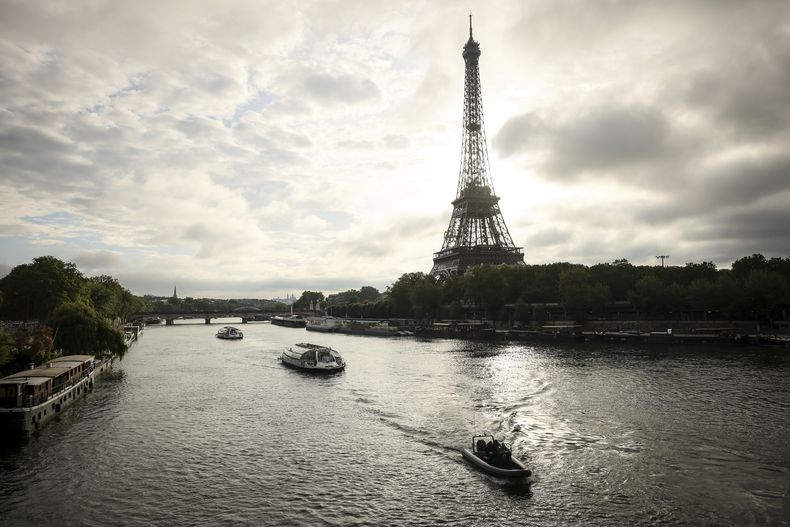 Las embarcaciones navegan por el río Sena cerca de la torre Eiffel durante un ensayo para la ceremonia de apertura de los Juegos Olímpicos de París, el lunes 17 de junio de 2024. (AP Foto/Thomas Padilla)