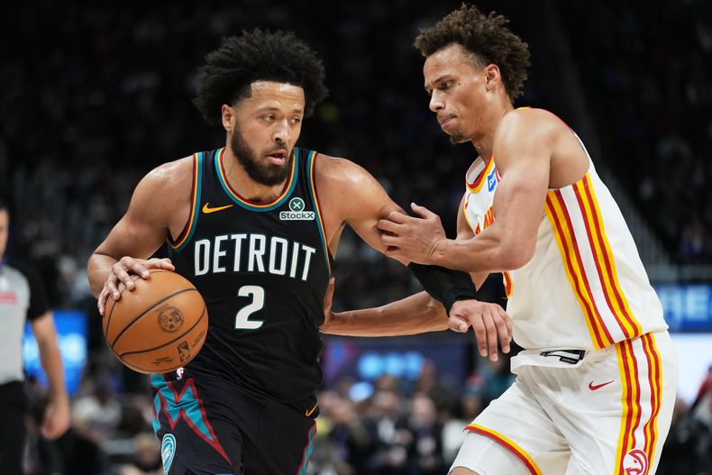 Cade Cunningham (2), de los Pistons de Detroit, lleva el balón ante la presión defensiva de Dyson Daniels, derecha, de los Hawks de Atlanta, durante la segunda mitad del juego de baloncesto de la NBA, el lunes 1 de diciembre de 2025, en Detroit. (AP Foto/Ryan Sun)