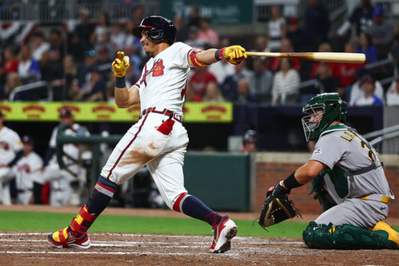 Mauricio Dubón, de los Bravos de Atlanta, batea un sencillo remolcador en la octava entrada del juego de béisbol de Grandes Ligas frente a los Atléticos, el lunes 30 de marzo de 2026, en Atlanta. (AP Foto/Colin Hubbard)