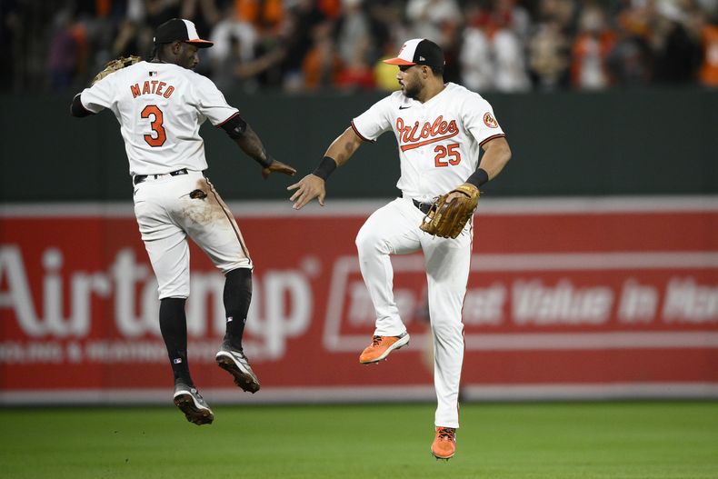 Anthony Santander (25) y Jorge Mateo, de los Orioles de Baltimore, celebran la victoria de su equipo sobre los Medias Rojas de Boston en el juego de béisbol el miércoles 29 de mayo de 2024, en Baltimore. (AP Foto/Nick Wass)