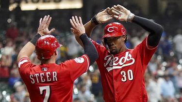 Will Benson de los Rojos de Cincinnati es felicitado por su compañero Spencer Steer Cincinnati Reds luego de conectar un cuadrangular de dos carreras en el noveno episodio del juego contra los Cerveceros de Milwaukee, en Milwaukee. Martes 25 de julio de 2023. (AP Foto/Morry Gash)