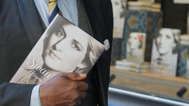 Un hombre sostiene un ejemplar del nuevo libro de Earl Spencer, hermano de la difunta princesa Diana, titulado Swan Song: Diana, My Sister, frente a una librería en el centro de Londres, el martes 22 de septiembre de 2026. (Foto AP/Kin Cheung)