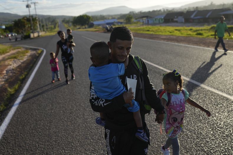 Miguel González y su familia, todos de origen venezolano, caminan en Santa Elena, Venezuela, hacia el transporte que los llevará a la frontera con Brasil, el miércoles 5 de abril de 2023. (AP Foto/Matias Delacroix)