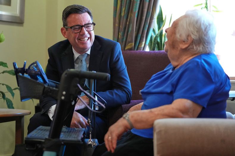 El primer ministro británico, Andy Burnham, habla con una interna durante una visita a una casa para ancianos en Londres, el miércoles 29 de julio de 2026. (AP Foto/Kirsty Wigglesworth, Pool)