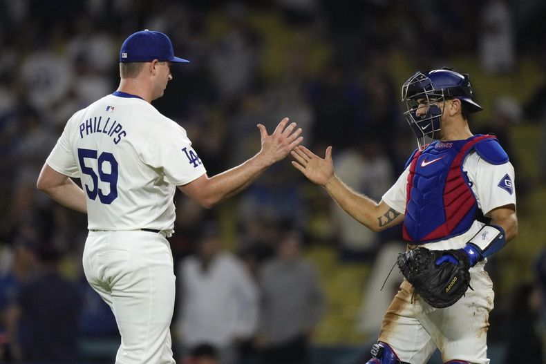 El lanzador Evan Phillips y el catcher Austin Barnes, de los Dodgers de Los Ángeles, se felicitan tras derrotar a los Orioles de Baltimore, el jueves 29 de agosto de 2024 (AP Foto/Mark J. Terrill)