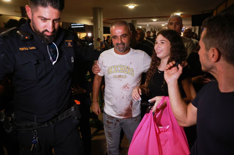 El pasajero israelí Yaniv Hayoun, con manchas de sangre en su camisa, y que iba a bordo del avión de FlyDubai que aterrizó de emergencia en Arabia Saudí, es recibido en la sala de llegadas del Aeropuerto Internacional Ben Gurion, cerca de Tel Aviv, Israel, el miércoles 30 de septiembre de 2026. (AP Foto/Tomer Appelbaum)