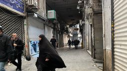 Varias personas pasean por una calle del principal bazar de Teherán, con las tiendas cerradas debido a las protestas, el 6 de enero de 2026. (AP Foto/Vahid Salemi)