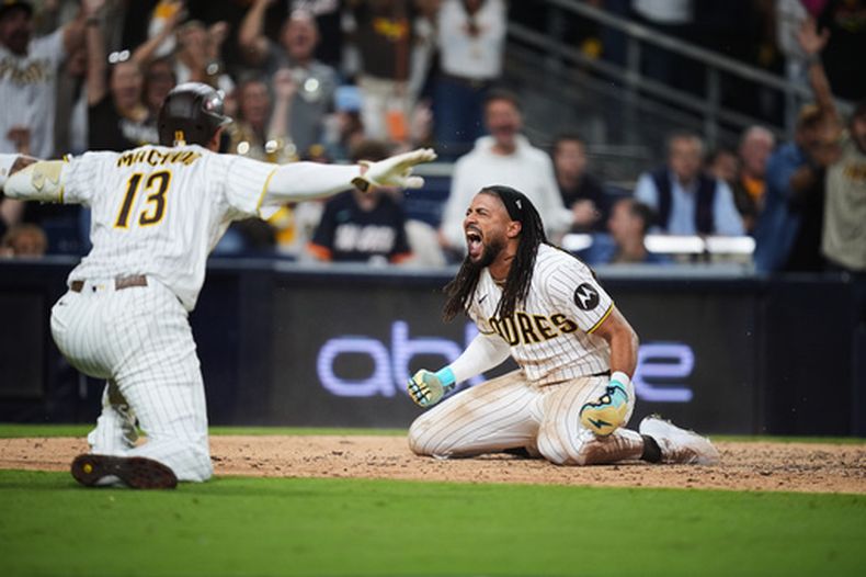 El jardinero de los Padres de San Diego, Fernando Tatis Jr., celebra con el tercera base Manny Machado (13) tras anotar mediante un robo de base y un error de los Cachorros de Chicago durante la séptima entrada del primer juego de la serie de comodines de los playoffs de la Liga Nacional de béisbol, el 29 de septiembre de 2026, en San Diego. (Foto AP/Gregory Bull)
