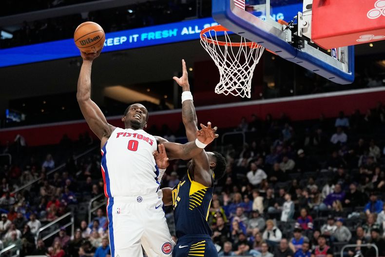 Jalen Duren (0), de los Pistons de Detroit, se alista para retacar el balón sobre Bennedict Mathurin, de los Pacers de Indiana, durante la primera mitad del juego de baloncesto de la NBA, el lunes 17 de noviembre de 2025, en Detroit. (AP Foto/Ryan Sun)