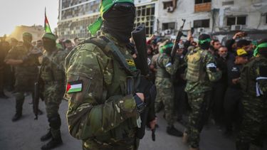 ARCHIVO - Combatientes de las Brigadas Qassam, el ala militar de Hamás, controlan a la multitud a la llegada de los vehículos de la Cruz Roja para recoger a rehenes israelíes durante un acuerdo de cese de fuego entre Israel y Hamas, en Ciudad de Gaza, el 19 de enero de 2025. (AP Foto/Abed Hajjar, archivo)