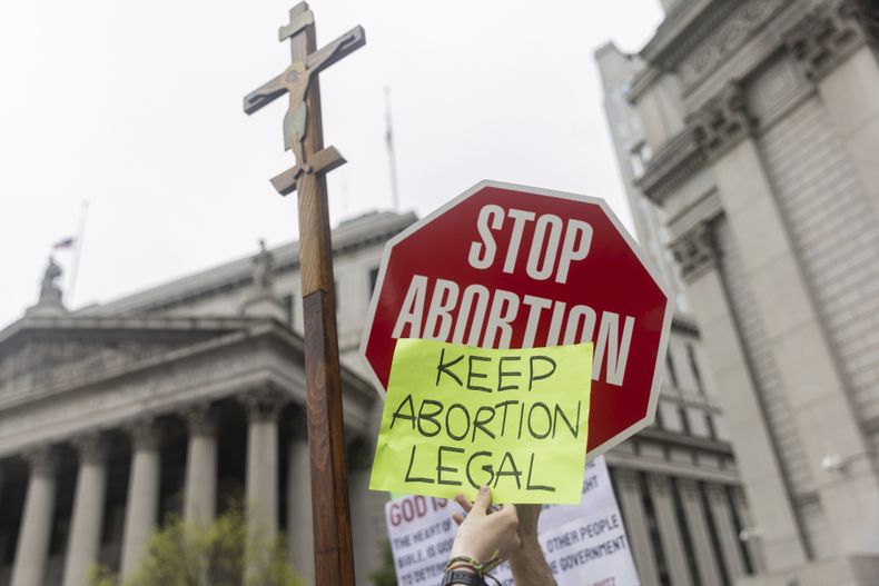 En esta imagen de archivo, manifestantes muestran mensajes contrarios en el exterior de una corte federal de Manhattan durante una manifestación sobre el aborto, en Nueva York, el 14 de mayo de 2022. (AP Foto/Jeenah Moon, archivo)