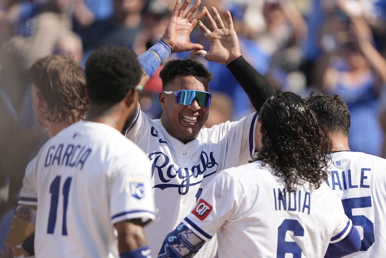 El venezolano Salvador Pérez de los Reales de Kansas City celebra con Jonathan India y sus compañeros su jonrón de tres carreras en la décima entrada del primer juego de la doble cartelera ante los Guardianes de Cleveland el sábado 26 de julio del 2025. (AP Foto/Charlie Riedel)