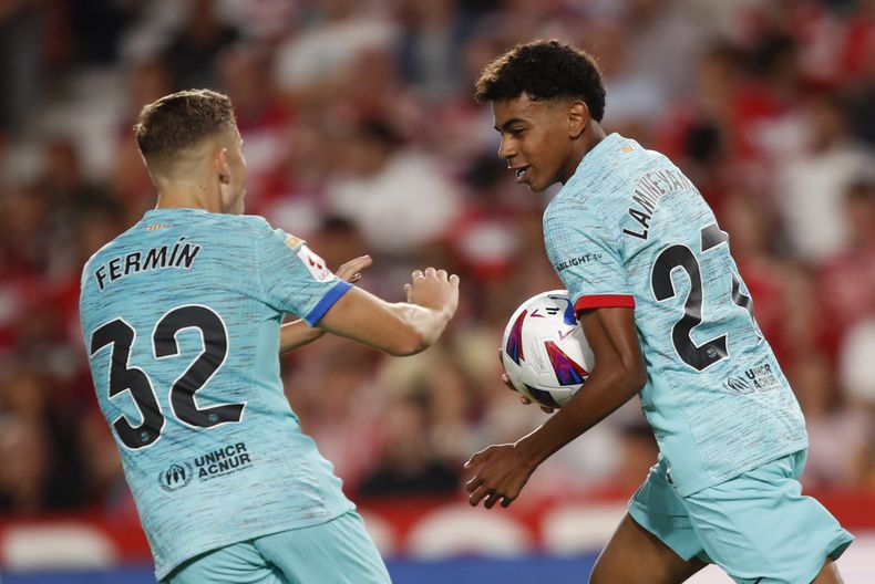 Lamine Yamal (derecha) celebra después de anotar el primer gol del Barcelona durante el partido de La Liga de España entre Granada y Barcelona en el estadio Los Carmanes, en Granada, España, el domingo 8 de octubre de 2023. (AP Foto/Fermin Rodriguez)