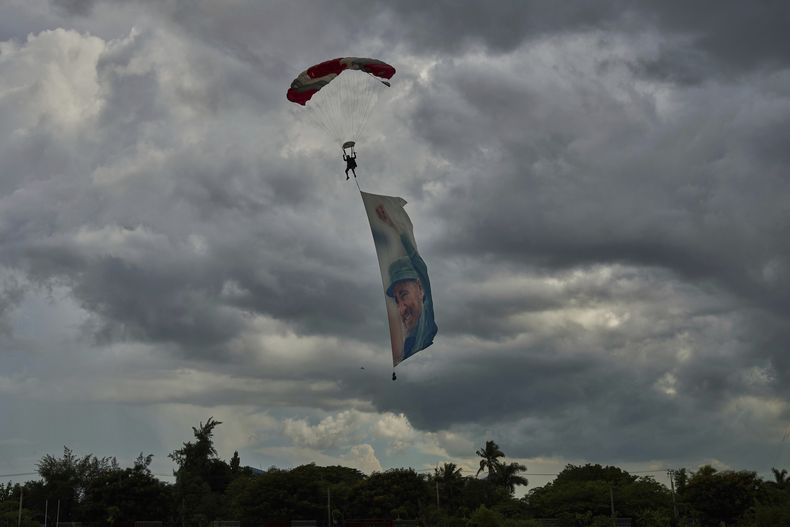 Un paracaidista iza una imagen del expresidente Fidel Castro durante una celebración en honor a su cumpleaños en La Habana, el martes 12 de agosto de 2025. (Foto AP/Ramón Espinosa)