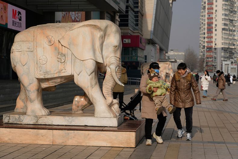Una mujer carga a un niño en Beijing, China, el 15 de enero de 2026. (AP Foto/Ng Han Guan)