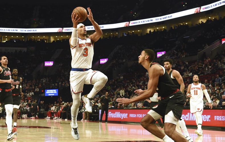 El base de los Knicks de Nueva York Josh Hart salta hacia la canasta con el balón frente al alero de los Trail Blazers de Portland Kris Murray en el encuentro de la NBA del jueves 14 de marzo del 2024. (AP Foto/Steve Dykes)