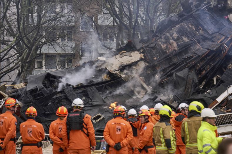 Una cuadrilla de bomberos observa los restos de un edificio en el lugar donde se registró una explosión que destruyó varios apartamentos, en La Haya, Holanda, el sábado 7 de diciembre de 2024. (AP Foto/Phil Nijhuis)