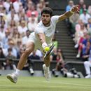 Carlos Alcaraz devuelve ante Novak Djokovic en la final de Wimbledon, el domingo 16 de julio de 2023, en Londres. (AP Foto/Kirsty Wigglesworth)
