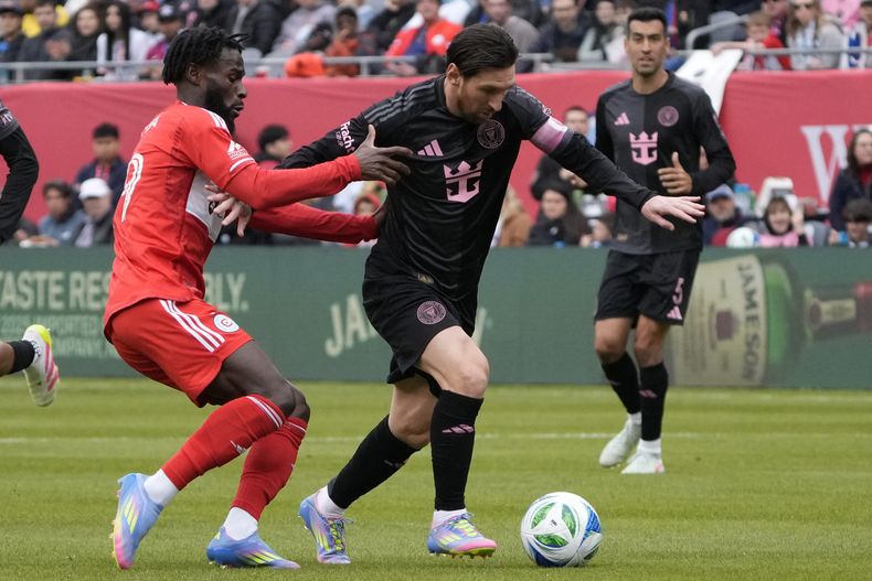 El delantero del Chicago Fire Jonathan Bamba, a la izquierda, defiende al delantero del Inter Miami Lionel Messi, a la derecha, durante la segunda mitad de un partido de fútbol de la MLS, el domingo 13 de abril de 2025, en Chicago. (AP Foto/David Banks)