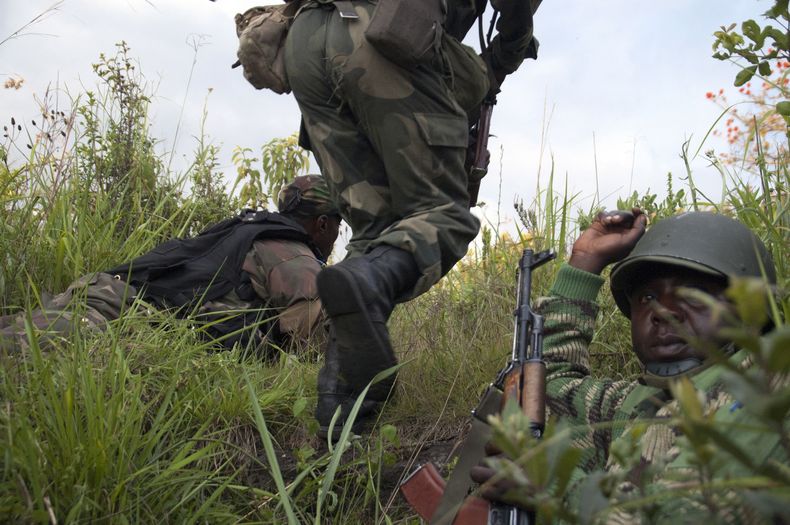 Soldados del Ej&eacute;rcito del Congo avanzan bajo fuego en Kasanza, una zona ocupada por rebeldes, el viernes 25 de octubre de 2013. El gobierno del Congo y los rebeldes del movimiento M23 informaron que se ha reanudado la violencia entre las dos partes