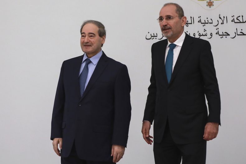 El ministro de Asuntos Exteriores de Jordania, Ayman Safadi (derecha), y su homólogo sirio Faisal Mekdad, durante una reunión en Amán, Jordania, el lunes 1 de mayo de 2023. (AP Foto/Raad Adayleh)