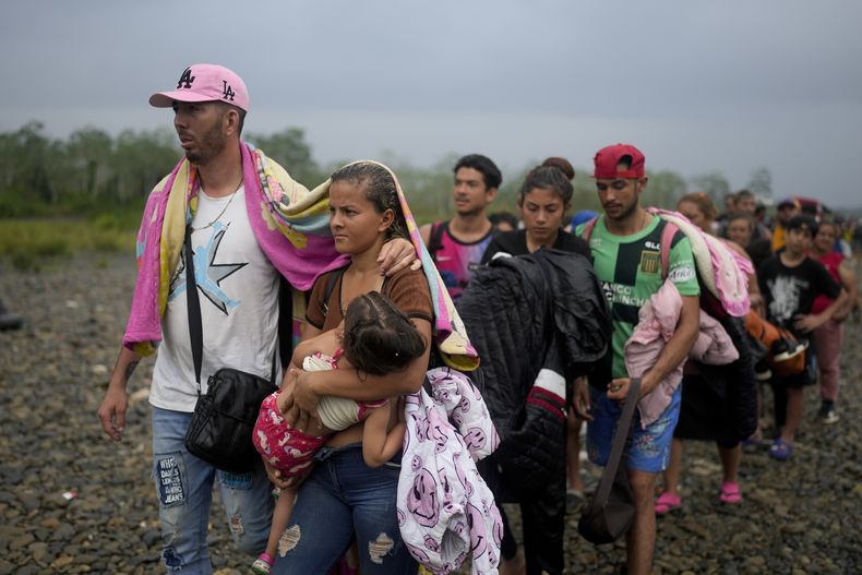 ARCHIVO - Numerosos migrantes hacen fila para subir a una embarcación en Bajo Chiquito, Panamá, el 7 de mayo de 2023, tras cruzar a pie la selva del Darién desde Colombia, con la esperanza de alcanzar Estados Unidos. (AP Foto/Natacha Pisarenko, archivo)