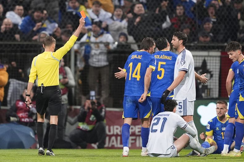 El árbitro Clement Turpin le muestra la tarjeta roja al italiano Alessandro Bastoni durante la final del repechaje al Mundial ante Bosnia y Herzegovina el martes 31 de marzo del 2026. (Fabio Ferrari/LaPresse via AP)