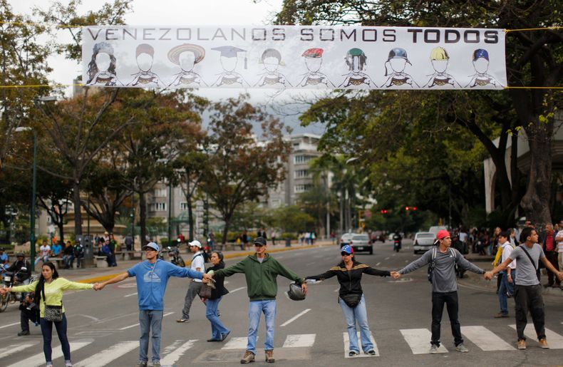Manifestantes se toman de las manos para bloquear una avenida en el barrio de Altamira en Caracas, Venezuela, el lunes 24 de febrero de 2014. La capital venezolana amaneci&oacute; el lunes en medio de nuevas tensiones luego de que decenas de manifestantes