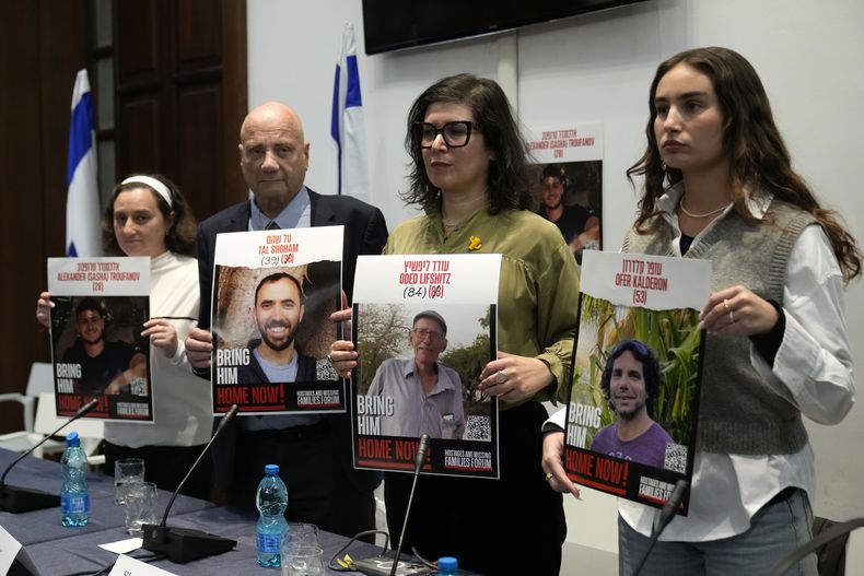 De izquierda a derecha, Elena Troufanov, Louis Har, Sharon Lifschitz y Gaya Kalderon, exrehenes israelíes y parientes de algunos que siguen retenidos por Hamás, muestran fotografías al final de una conferencia de prensa en Roma, el jueves 14 de noviembre de 2024. (AP Foto/Alessandra Tarantino)
