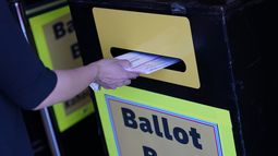 ARCHIVO - Una persona deposita papeletas de voto por correo en un buzón de entrega de papeletas de voto por correo en el departamento electoral del condado de Clark, 29 de octubre de 2020, en Las Vegas. (AP Foto/John Locher, Archivo)