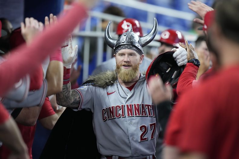 Jake Fraley de los Rojos de Cincinnati es felicitado por sus compañeros tras su jonrón con anotación de José Barrero y Curt Casali en la quinta entrada del juego ante los Marlins de Miami el sábado 13 de mayo del 2023. (AP Foto/Wilfredo Lee)